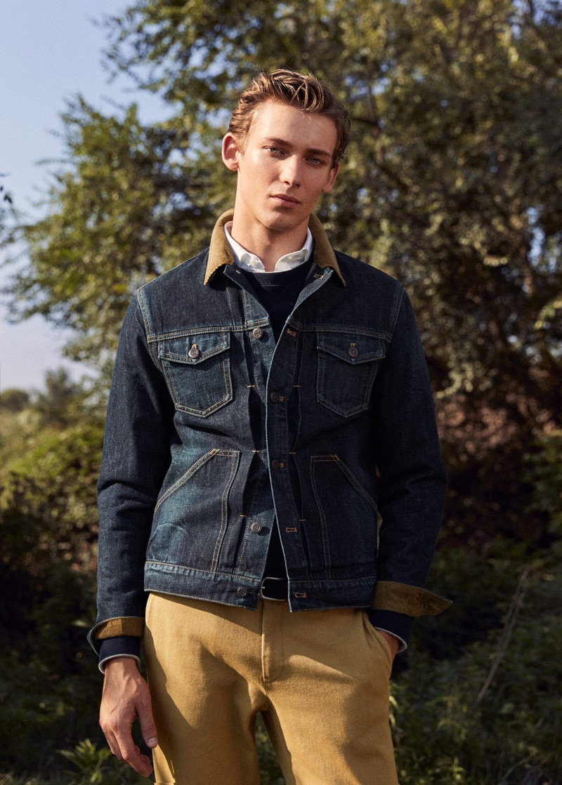 Sporting a classic men's outfit, Christoper Einla dons a jean jacket with khaki-colored pants by Mango.