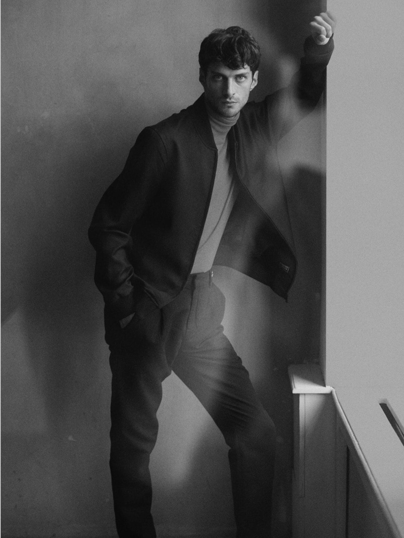 Matthew Bell sports a bomber jacket with a turtleneck and trousers by Scotch & Soda.