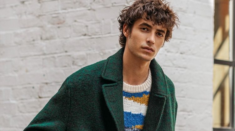 Oscar Kindelan dons a green coat with a graphic sweater from Reserved.
