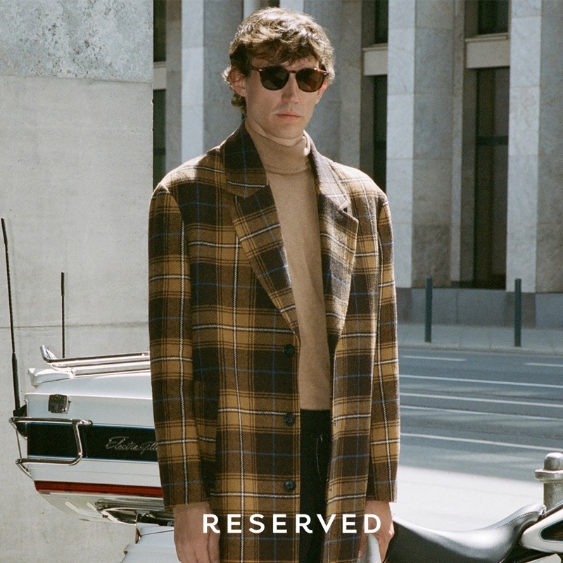 Thilo Muller dons a plaid coat and turtleneck sweater by Reserved.