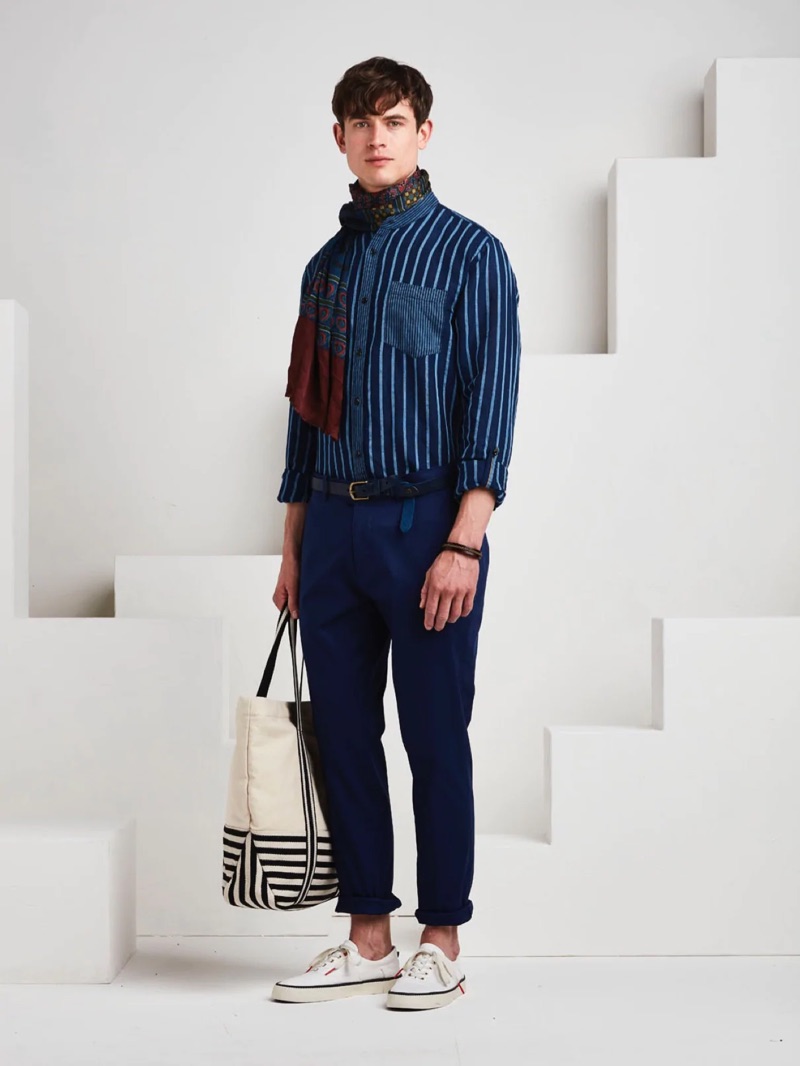 Showcasing navy tones, Luc van Geffen wears a Scotch & Soda striped top with chinos, a patterned scarf, and a braided belt.