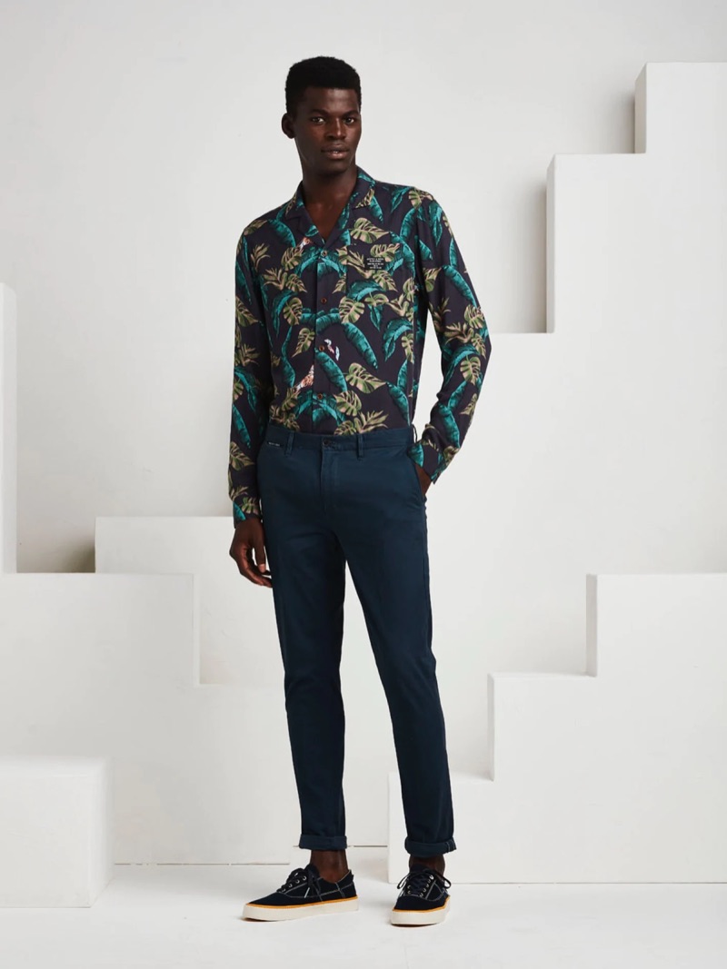 Donning a tropical print shirt from Scotch & Soda, Evandro Laurens also wears chinos and sneakers.