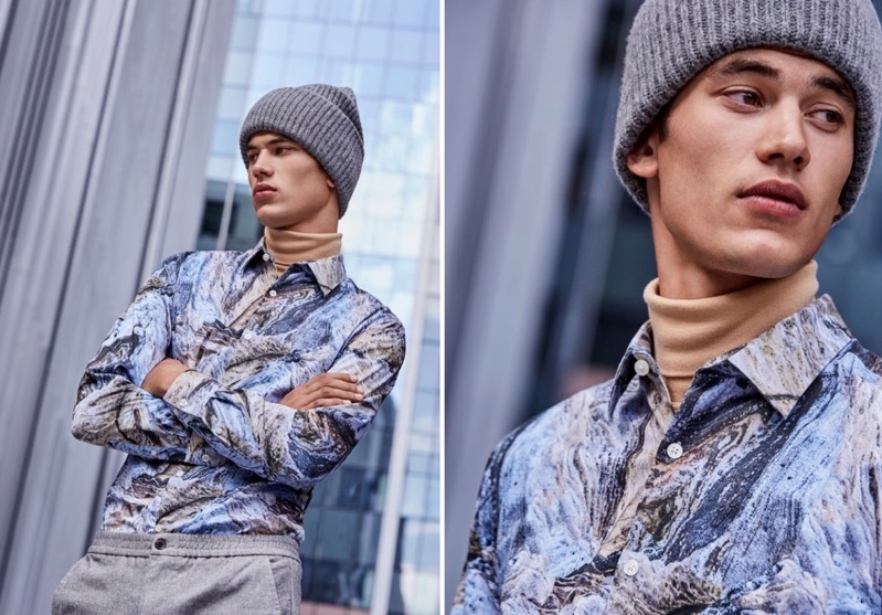 Making an artsy statement, Finn Hayton wears a graphic shirt with a turtleneck, knit beanie, and joggers from Simons.