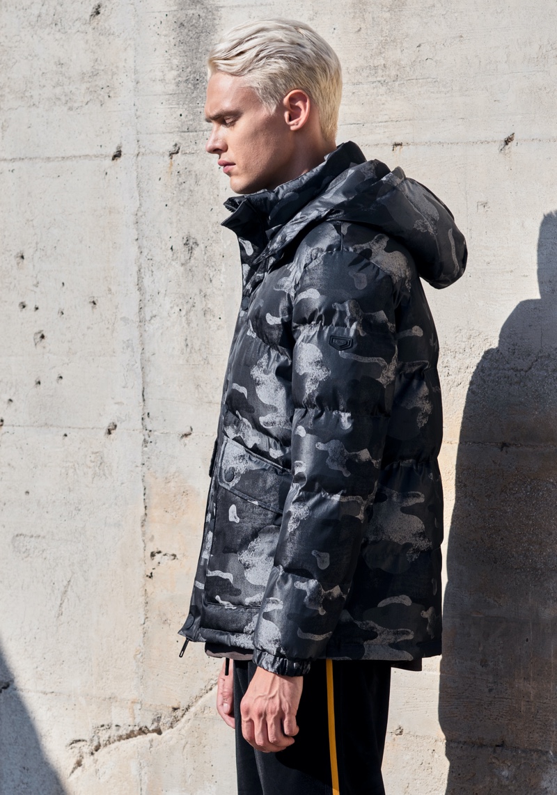 Delivering a side profile, Simon Kuzmickas wears a camouflage print jacket by Antony Morato.