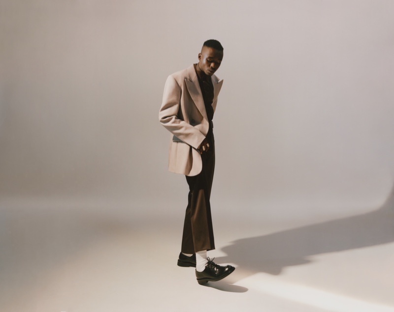 Taking to the studio, Ashton Sanders wears a Raf Simons blazer, Bianca Saunders shirt, Lemaire trousers, Gucci socks, and Prada shoes.