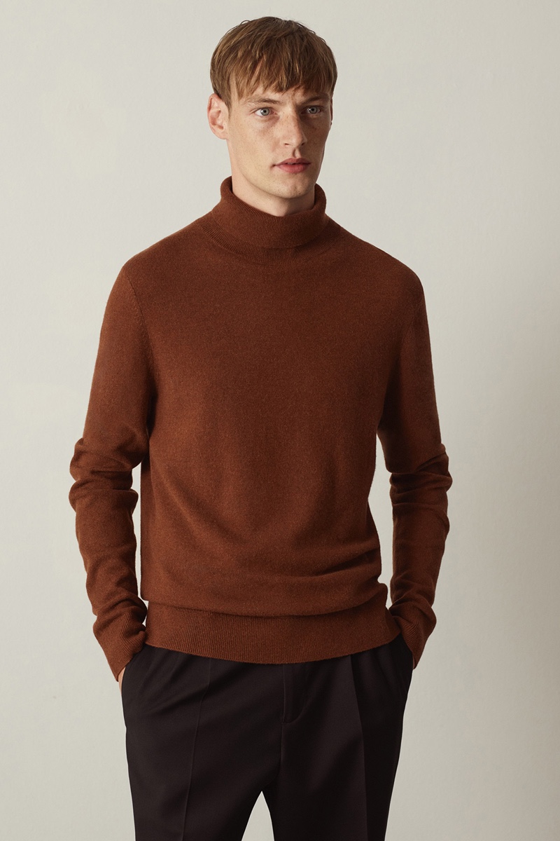 Front and center, Roberto Sipos sports a COS turtleneck sweater with pleated trousers.