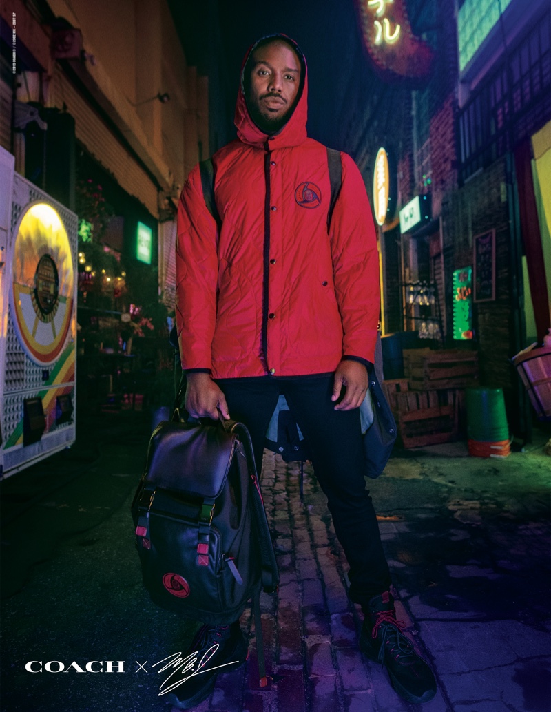 Front and center, Michael B. Jordan wears a red jacket and backpack from his Coach capsule collection.