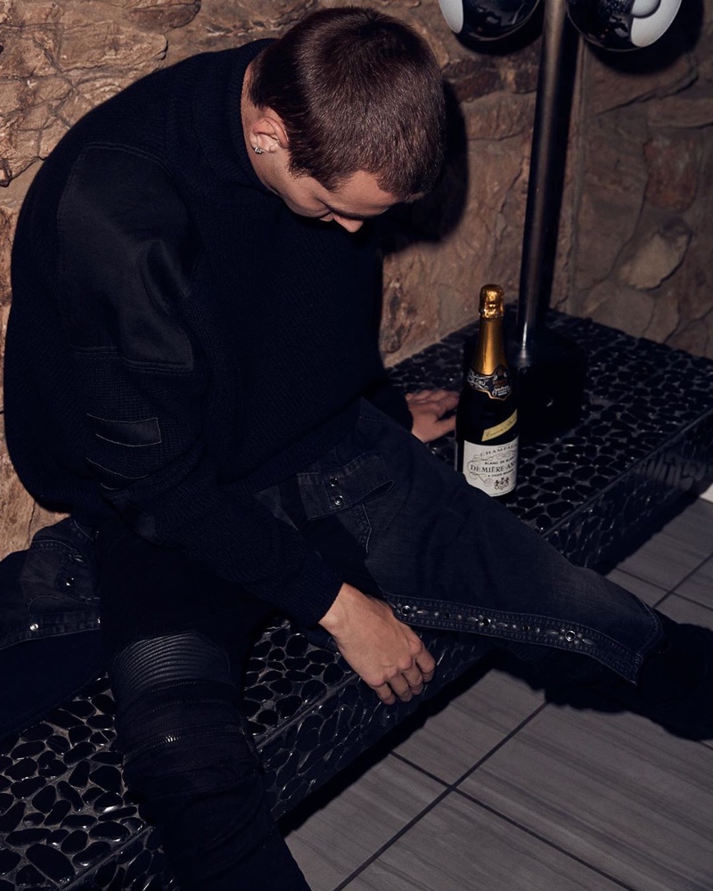 Model Yuri Pleskun wears an AMIRI military patch knit $950 with black MX2 jeans $1,150.