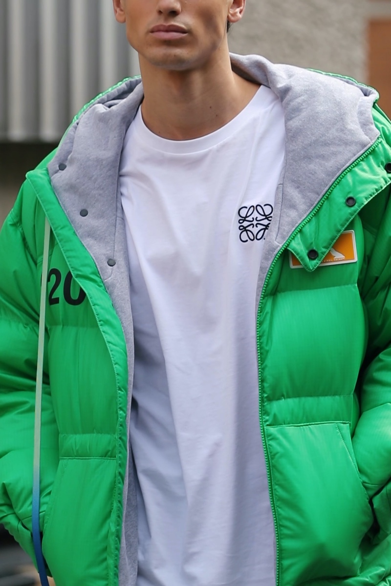 Embracing an "Urban Uniform," Gerard Sabe wears an Off-White hooded puffer jacket in green with a Loewe logo t-shirt.