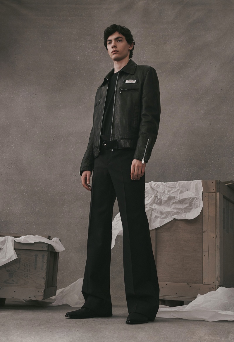Model Lev Uliesov wears a black leather jacket with pleated trousers from the Givenchy Atelier collection.