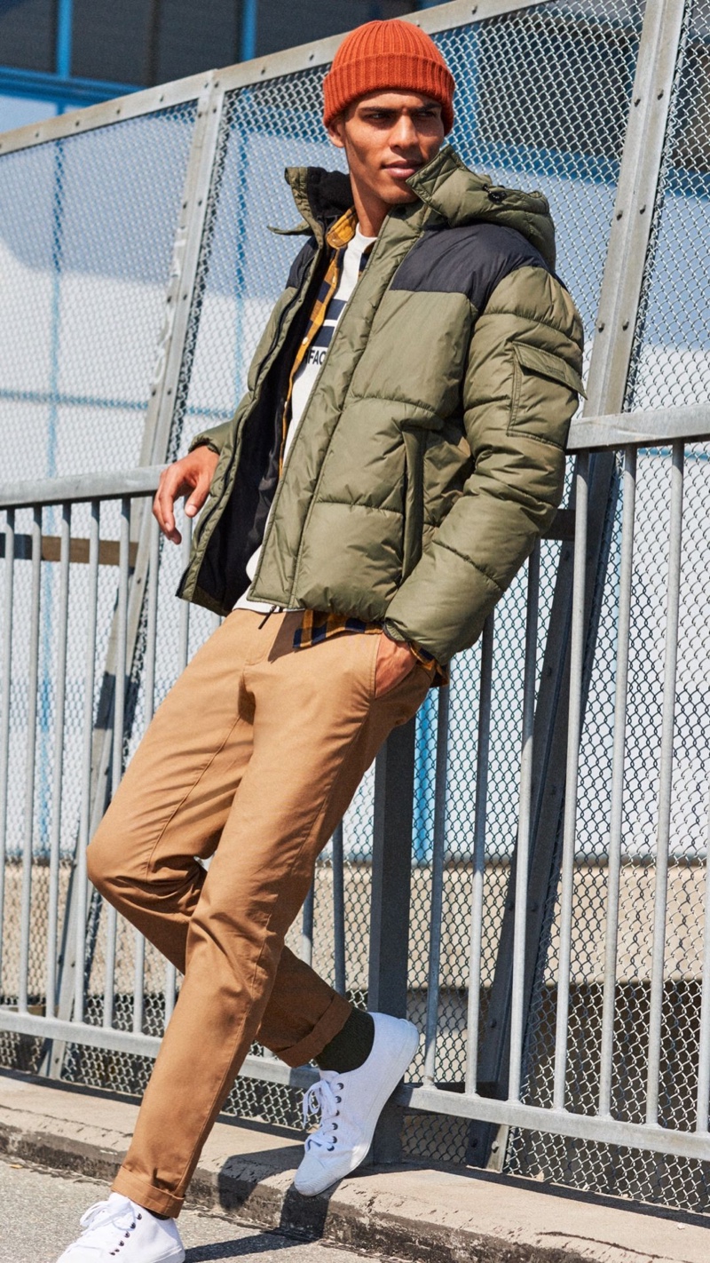 Reuniting with H&M for fall, Geron McKinley dons a puffer jacket with khaki pants and white sneakers.