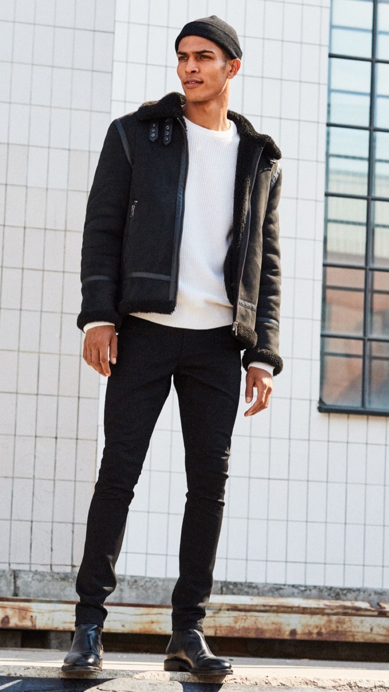 A trendy vision, Geron McKinley embraces black and white in a shearling jacket with skinny jeans and boots.