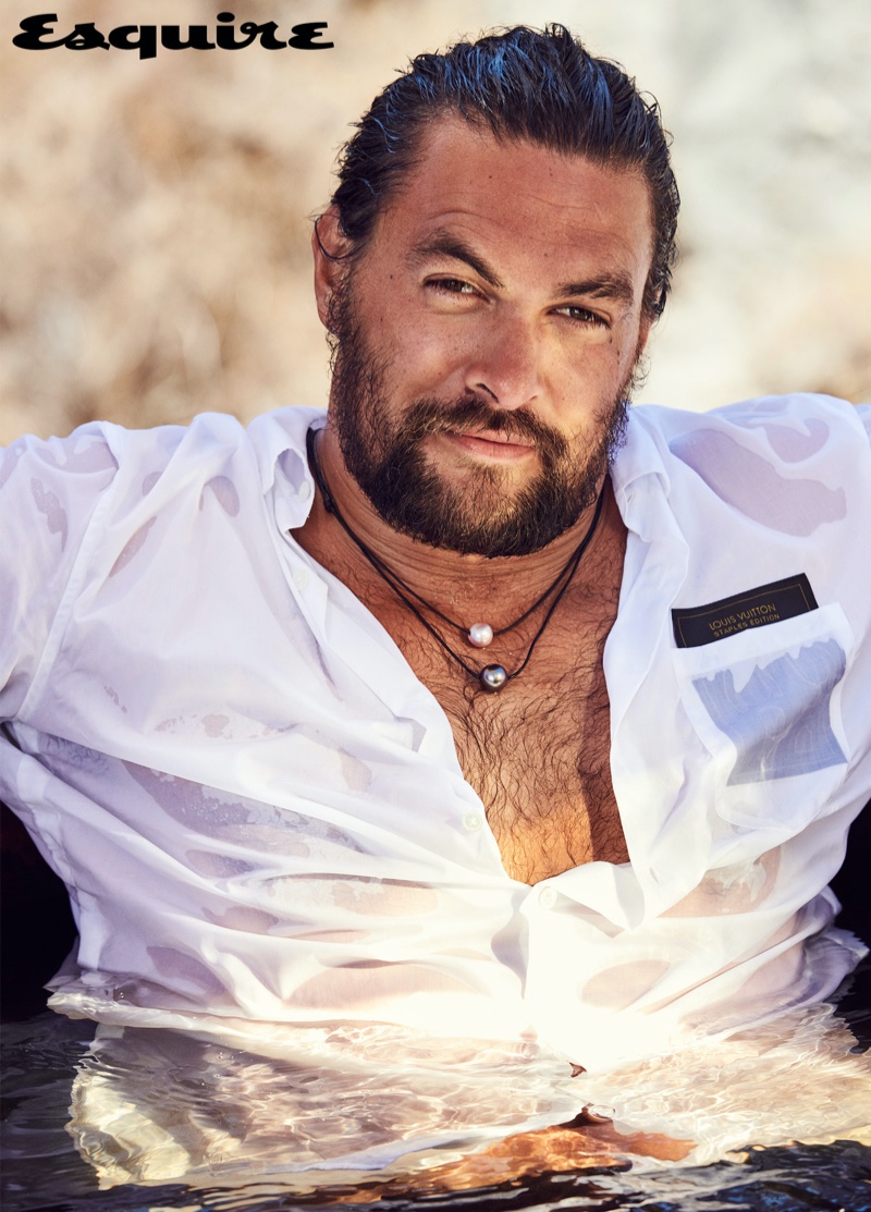 Connecting with Esquire, Jason Momoa wears a Louis Vuitton shirt with Rainbow Gems necklaces.