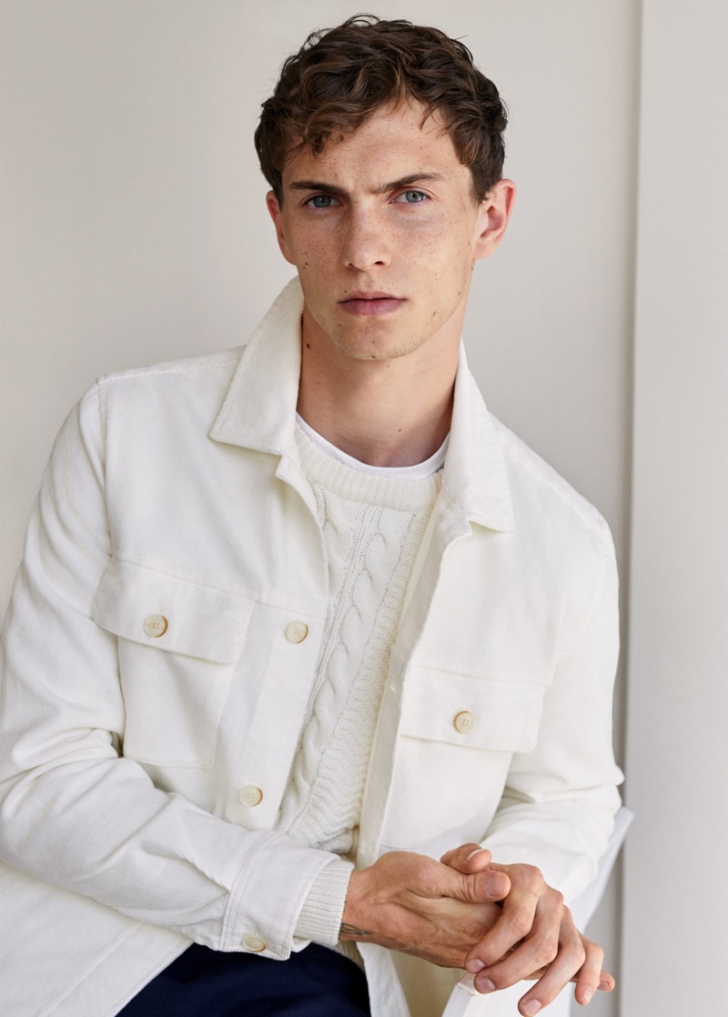 Luc Defont-Saviard wears a white shirt jacket and cable-knit sweater from Mango.