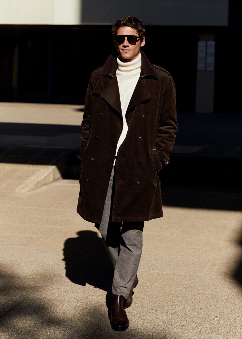 Roch Barbot dons a brown corduroy trench coat with a turtleneck sweater and trousers from Mango.
