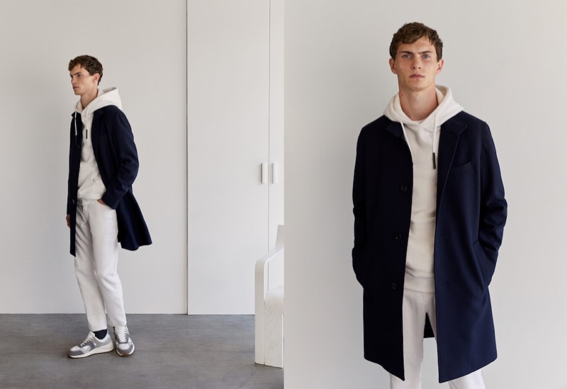 Making a case for neutrals, Luc Defont-Saviard dons an off-white hoodie and pants with a sleek navy coat by Mango.