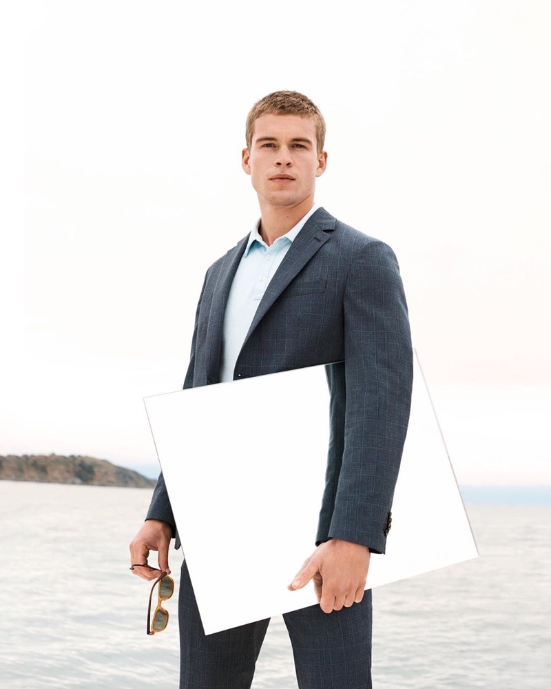 Model Mitchell Slaggert wears a navy suit with a light blue shirt by Banana Republic.