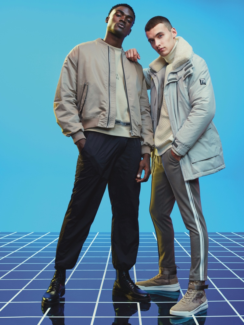 Front and center, models Davidson Obennebo and Dom Stowell wear neutral-colored fashions from River Island's Electric Xmas collection.