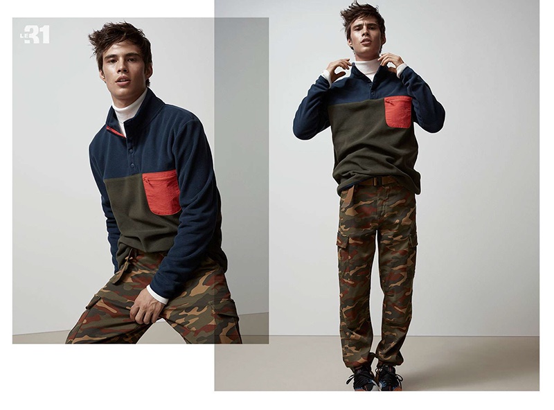 Model Louis Baines rocks a LE 31 fleece sweatshirt, turtleneck, and camouflage print cargo pants.