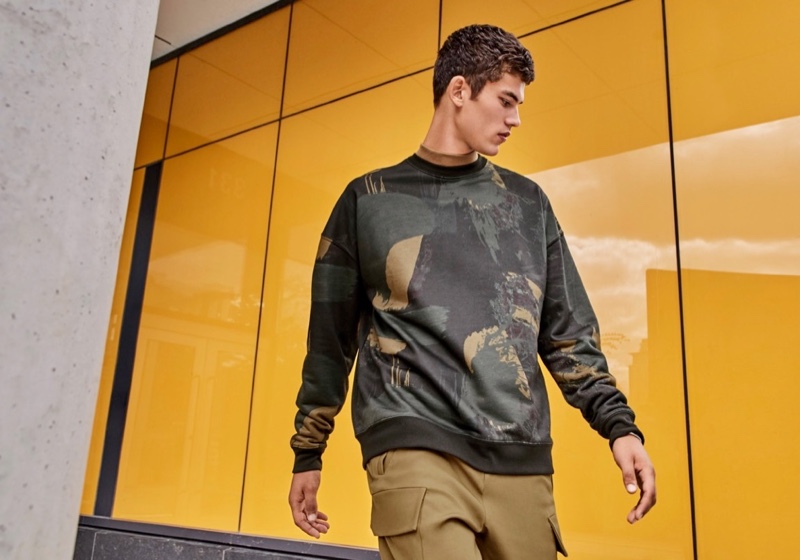 Going sporty, Finn Hayton dons a dark abstract sweatshirt by LE 31.