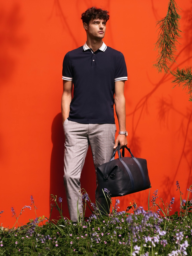 Front and center, Hannes Gobeyn dons a Ted Baker polo shirt with smart trousers.