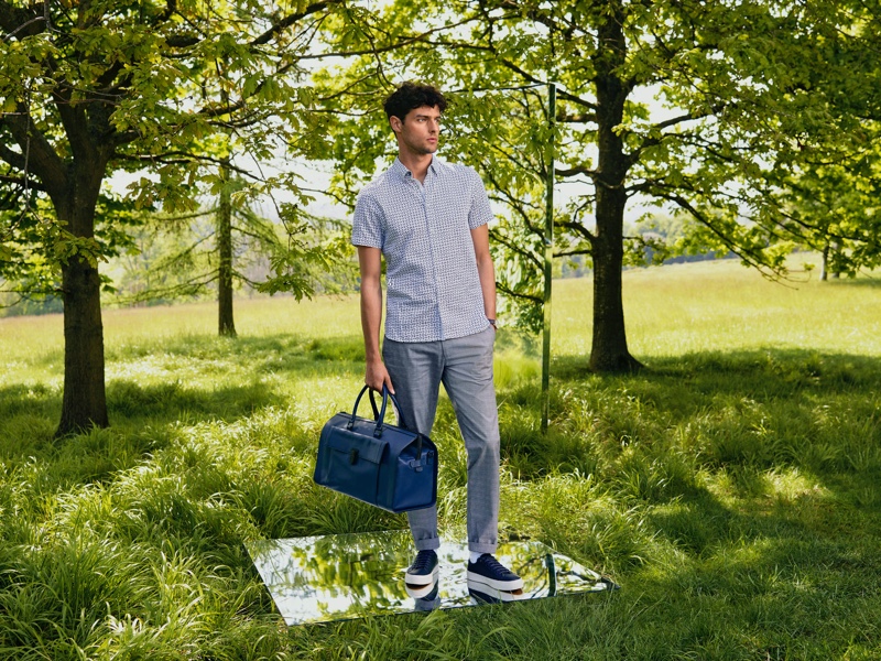 Venturing outdoors, Hannes Gobeyn models a sleek look from Ted Baker.