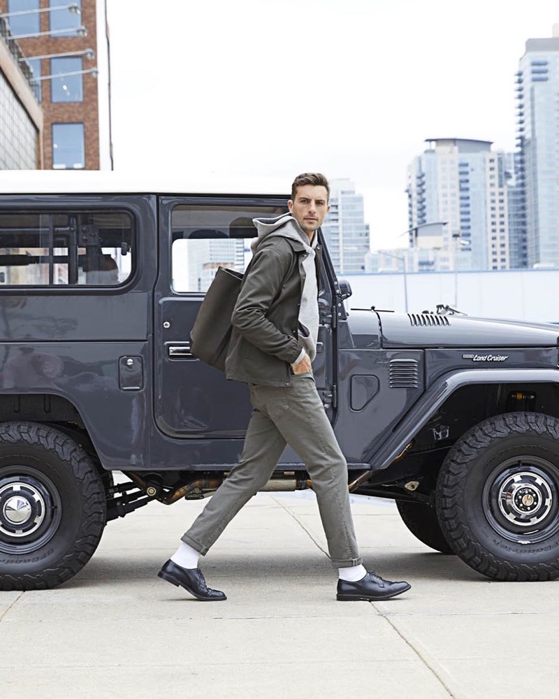 Rafael Lazzini sports a Todd Snyder coach's jacket $498 and chinos $228 with a Todd Snyder + Champion hoodie $138. A Mismo tote $600 and Alden plain toe blucher shoes $756 complete his look.