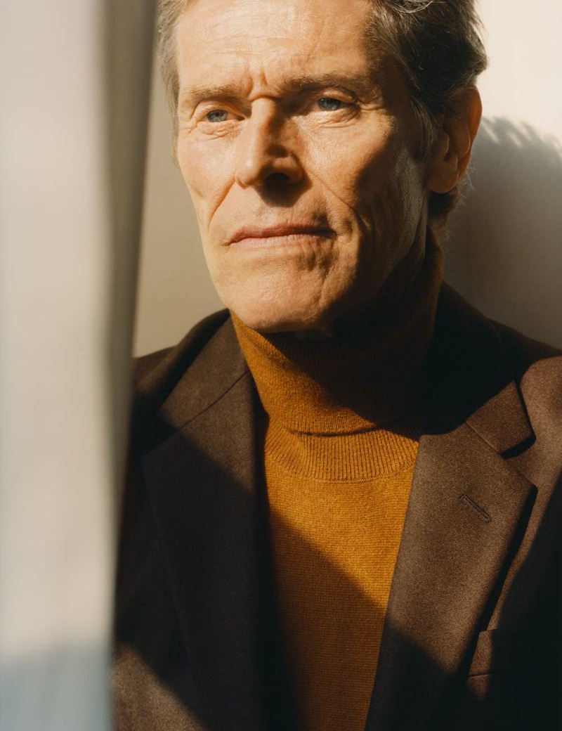 A smart vision, Willem Dafoe sports a Prada wool suit jacket and turtleneck sweater.