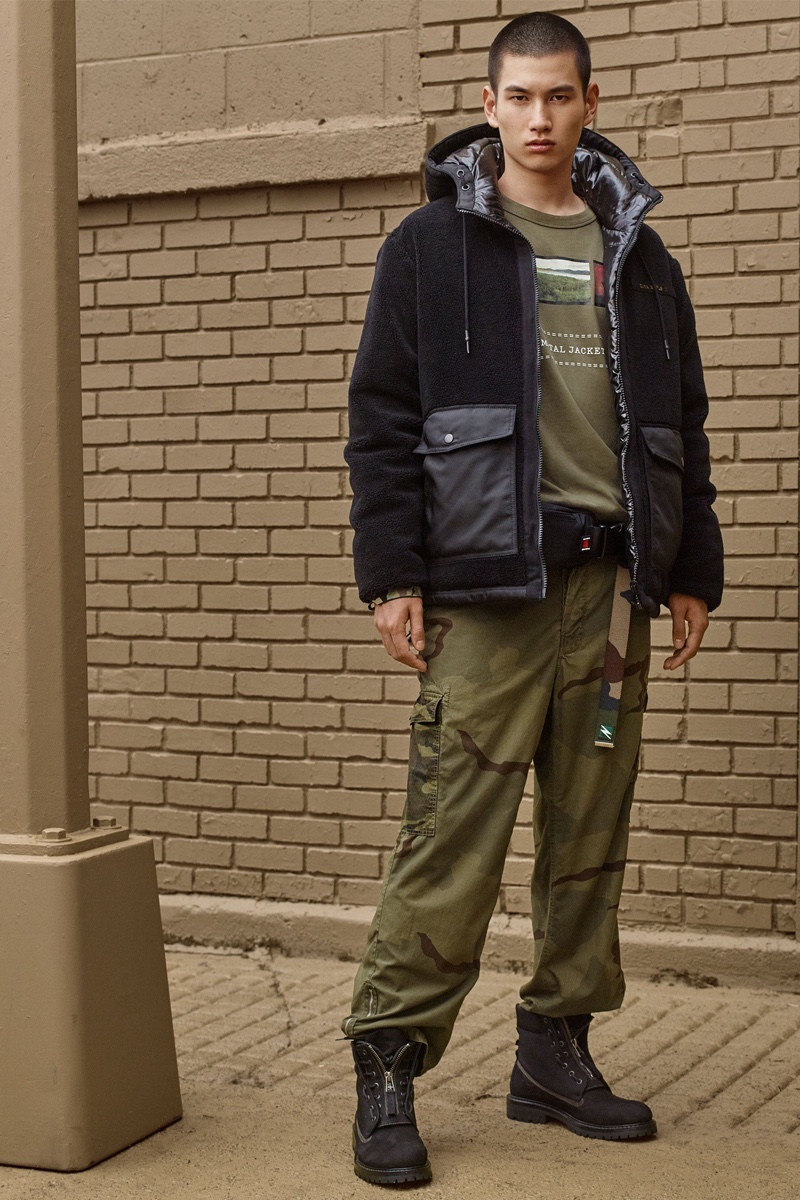 Kohei Takabatake sports a fleece jacket with a graphic tee and camouflage print cargo pants from Zara SRPLS' fall-winter 2019 men's collection.