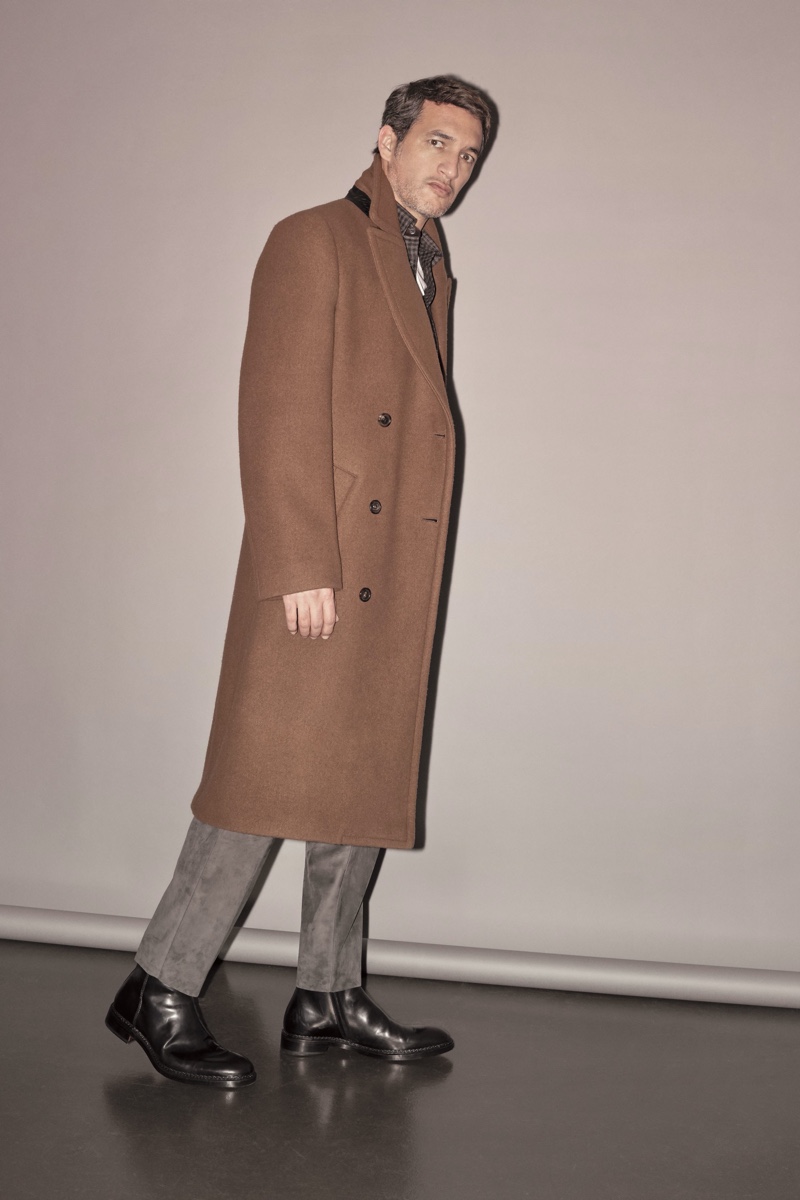 Ilay Kurelovic dons a long brown coat from Brioni's fall-winter 2019 collection.