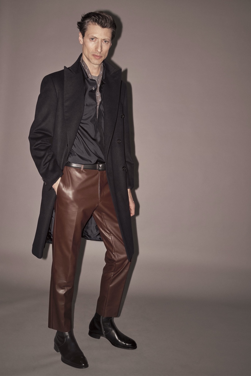 Jonas Mason rocks brown leather trousers with a long coat from Brioni's fall-winter 2019 collection.