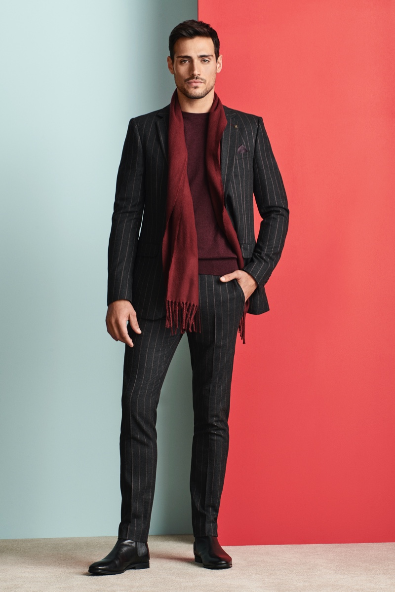 A sleek vision in a pinstripe suit, Richard Deiss accessorizes his Burton look with a scarf and boots.