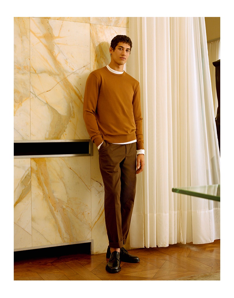 Malik Al Jerrari sports a brown sweater with wool flannel trousers from Club Monaco.