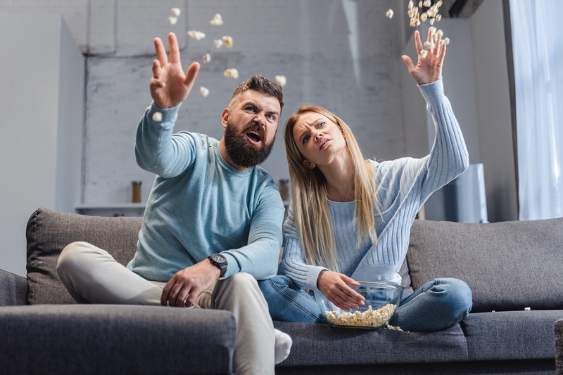 Couple Throwing Popcorn Couch Unhappy