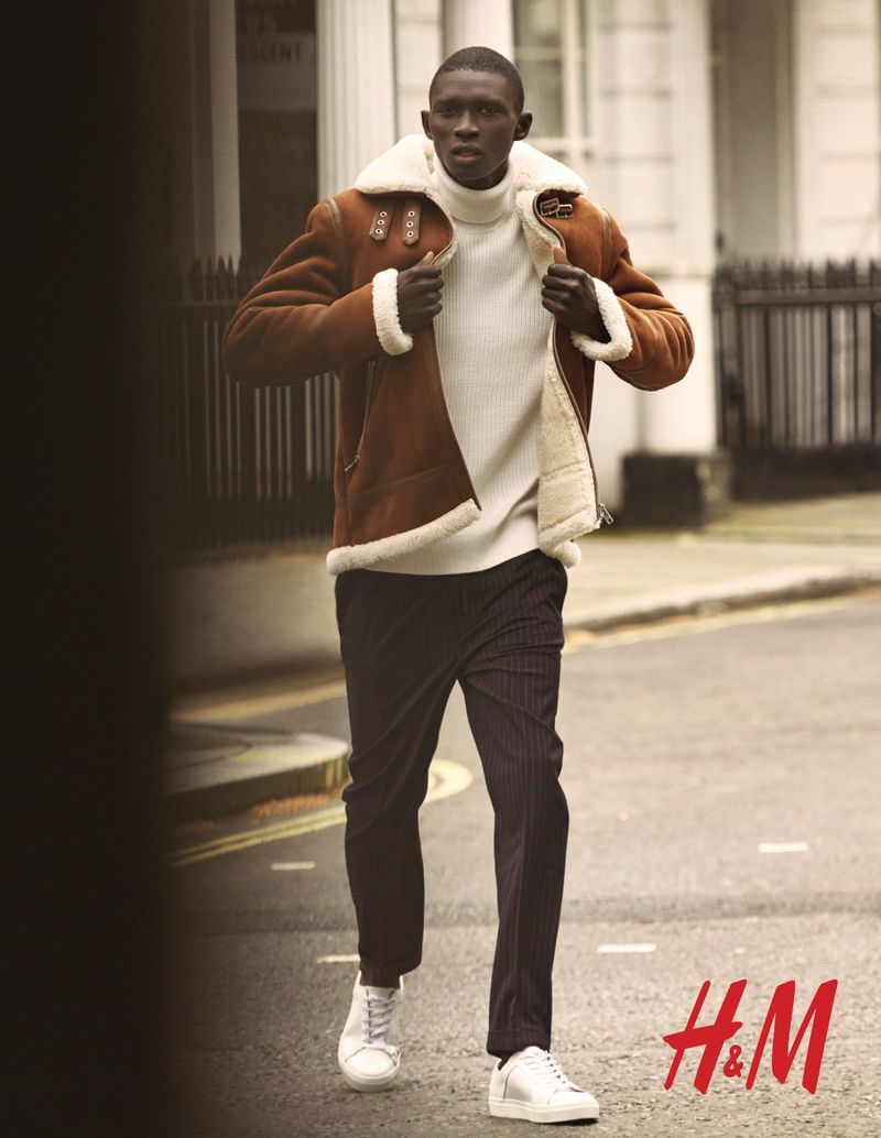 Portuguese model Fernando Cabral dons a faux suede shearling jacket with a ribbed sweater and striped trousers from H&M.