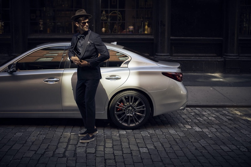 A stylish vision, Max Jablonsky poses in front of an Infiniti car.