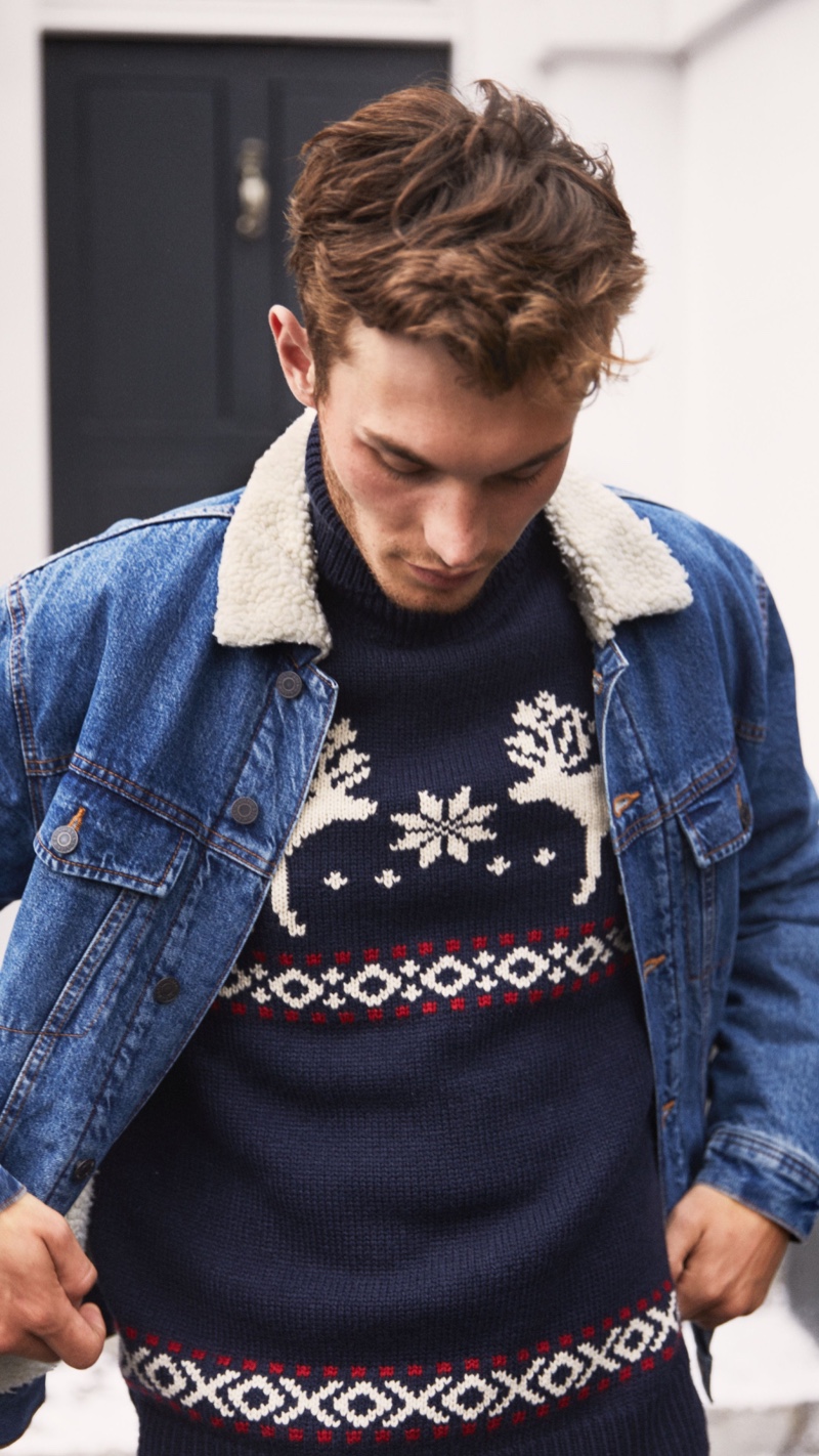Going casual in a denim jacket and festive holiday sweater, Kit Butler wears H&M.
