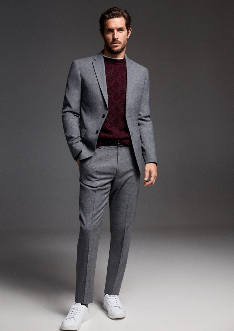 Donning a gray Mango suit, Justice Joslin also wears a knit sweater.