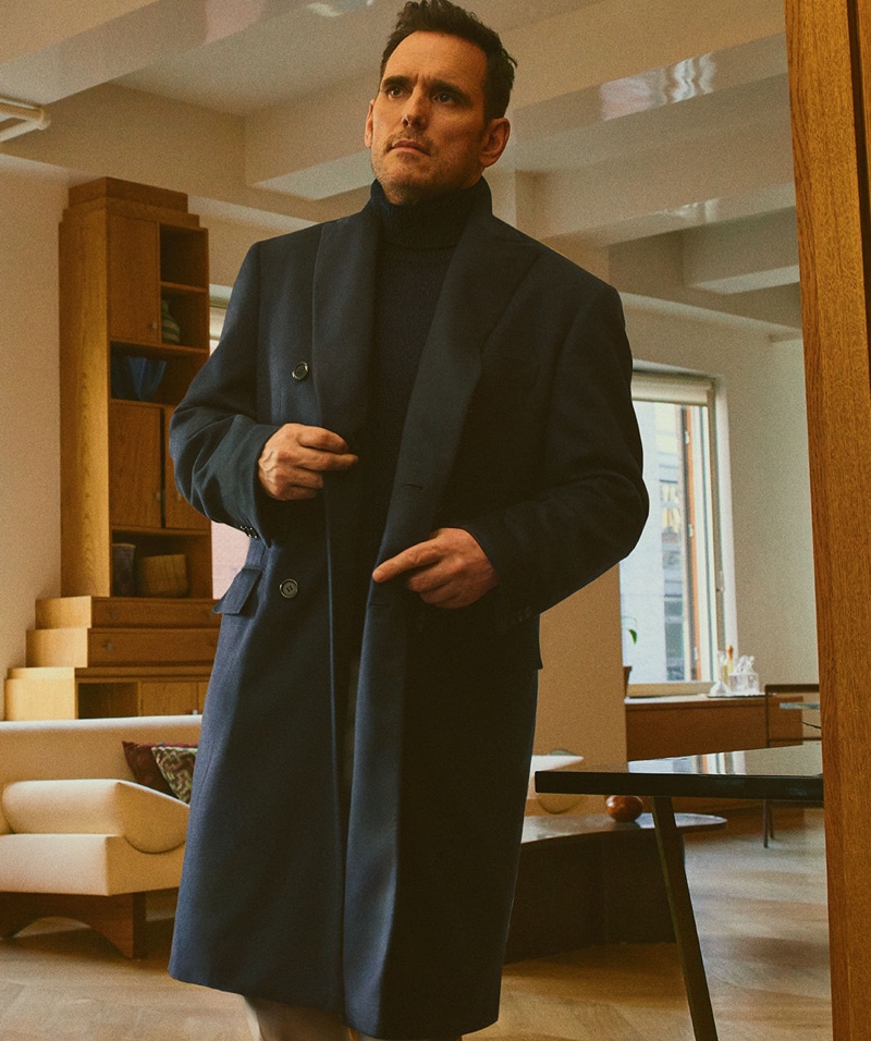 Ready to head out, Matt Dillon sports a sleek coat and turtleneck sweater by Brioni.