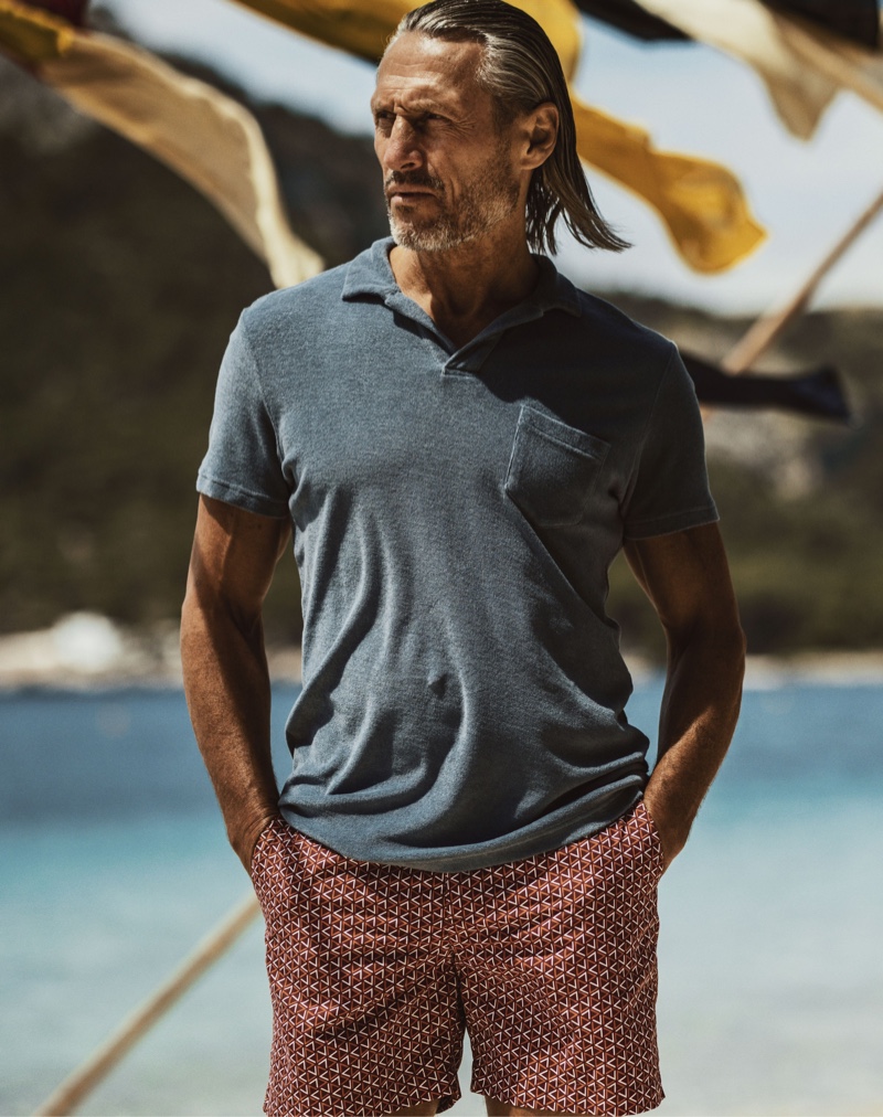 Stepping out, Rob Knighton dons an Orlebar Brown terry toweling shadow grey resort polo shirt $175 with mulberry mid-length swim shorts $275.