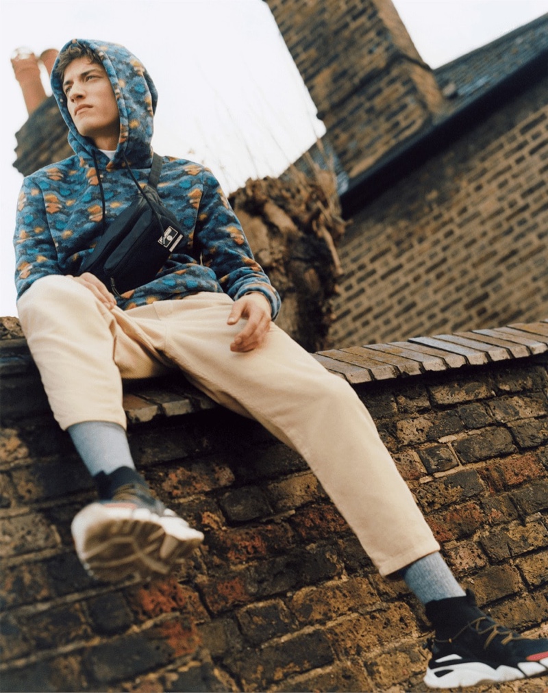 A laid-back vision, Serge Rigvava dons a printed hoodie with tan pants by Bershka.