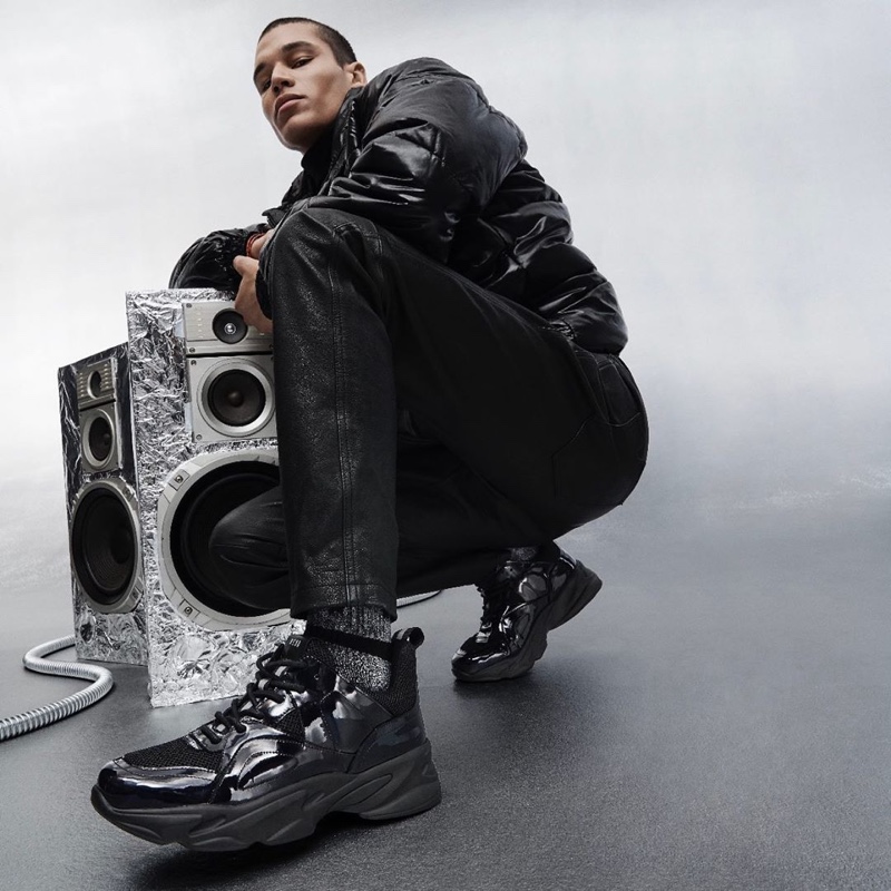 Embracing an all black look, T.J. Moore appears in Steve Madden's holiday 2019 campaign.