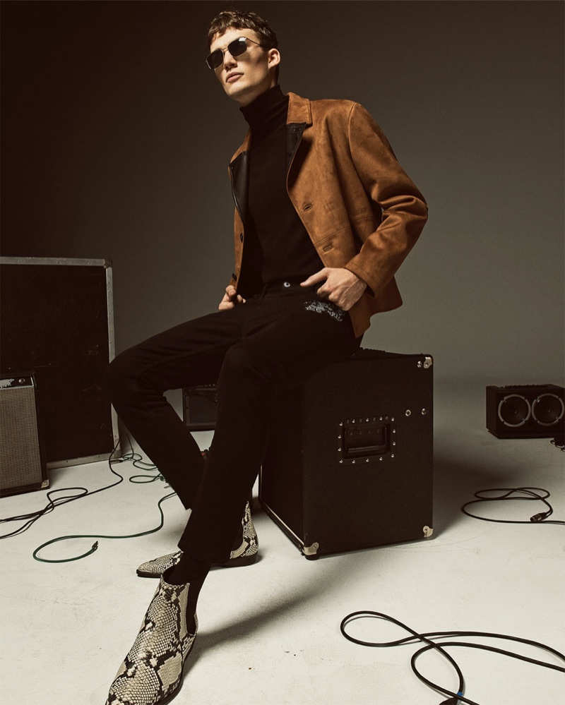 Lukas Adriaensens sports a faux suede jacket with a black turtleneck, pants, and reptile print boots by Zara.