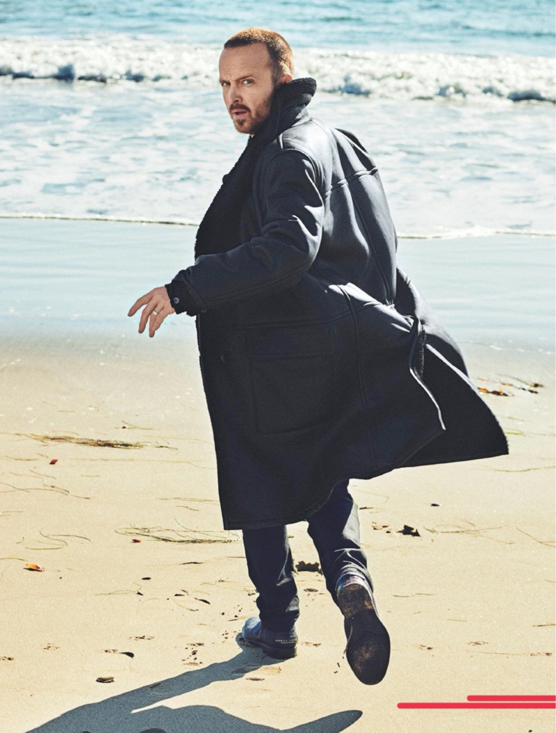 Taking to the beach with Men's Journal, Aaron Paul wears an Ermenegildo Zegna jacket, Mr P. turtleneck, Levi's jeans, and Kenneth Cole boots.