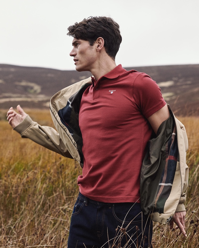 Venturing outdoors, Sam Way models a Barbour polo shirt with one of the brand's signature jackets.