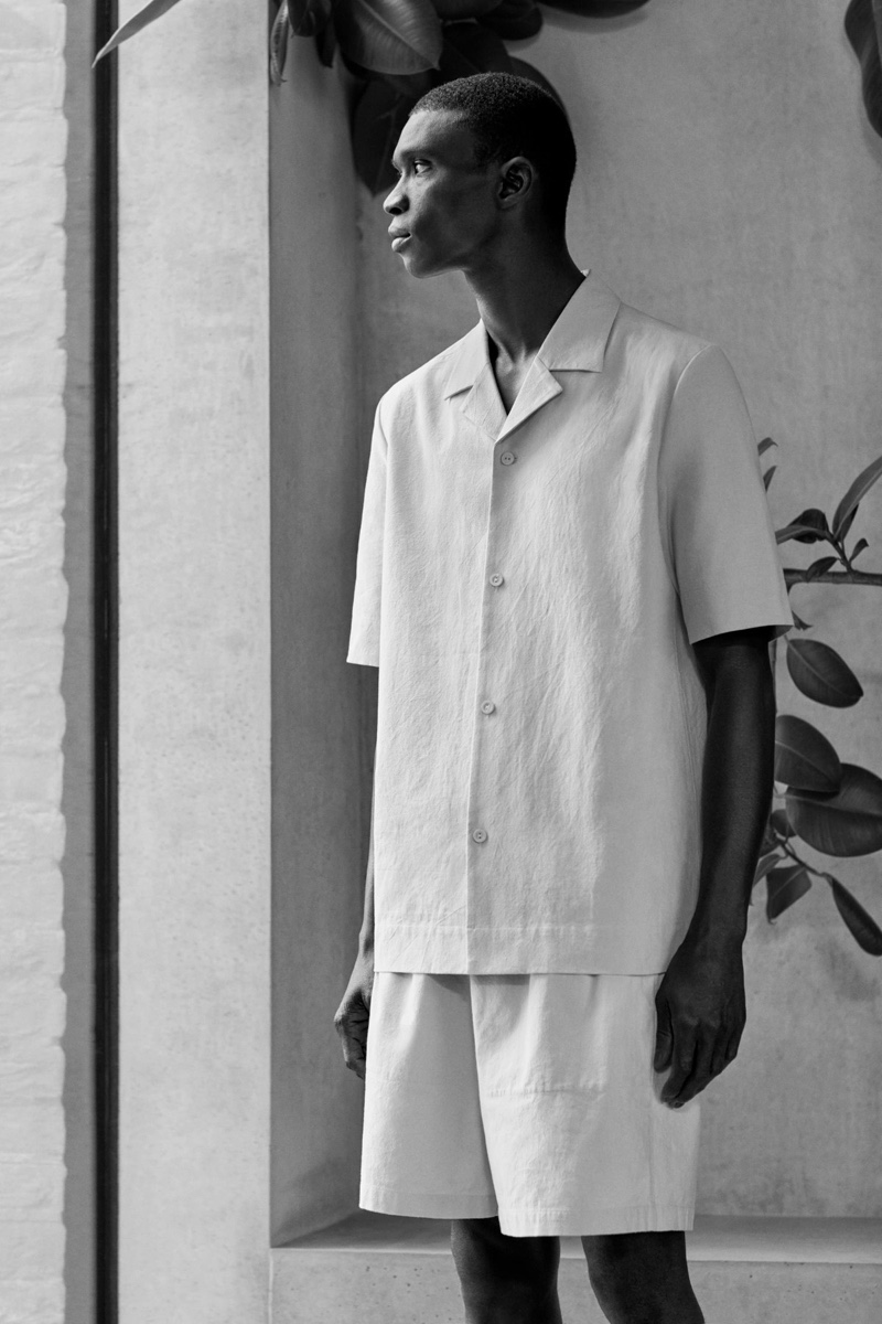 Model Fernando Cabral sports a short sleeved cotton shirt and boxy organic hemp shorts by COS.