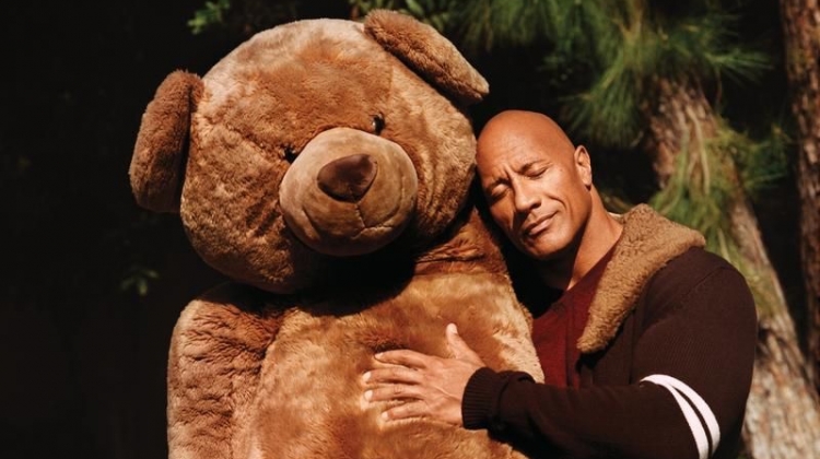 Hugging a giant teddy bear, Dwayne "The Rock" Johnson sports a Dolce & Gabbana cardigan, Brioni sweater, and Double RL jeans for WSJ. magazine.