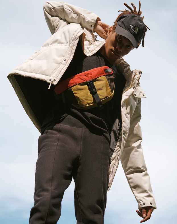 Connecting with East Dane, Seth Hill sports a Rag & Bone Standard Issue t-shirt, Champion track pants, The North Face box canyon jacket and horizon hat with a Marni colorblock belt bag.