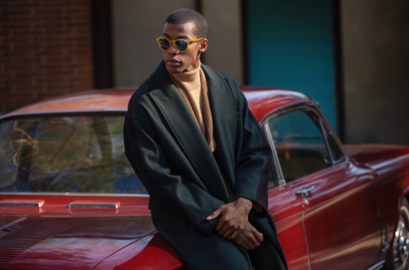 Magor Meng wears a BOSS corduroy sportcoat with an A.P.C. turtleneck sweater, Maison Kitsune wrap coat, and Persol PO3152S sunglasses.