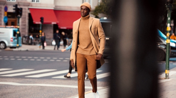 Embracing camel tones, Davidson Obennebo wears a sleek H&M look that includes a classic turtleneck sweater.